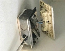 mala instalacion electrica, con la tapa saliendo de la caja